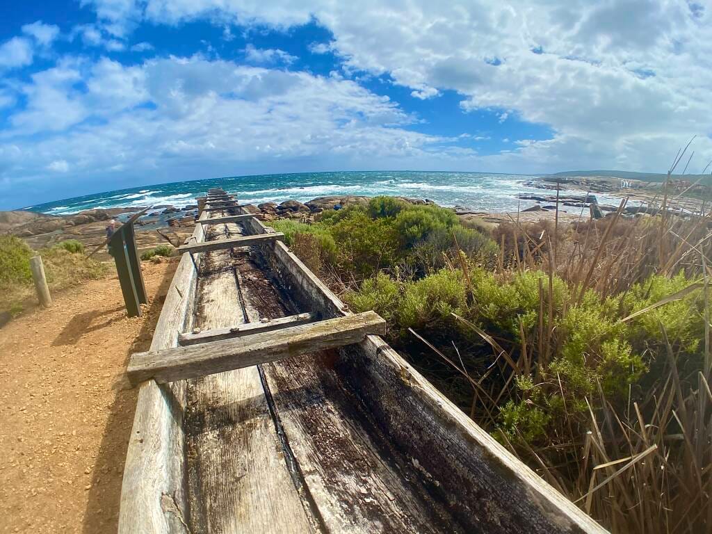 This image features a relic of traditional water wheel engineering, a technology that powered localities through the elemental force of flowing water.