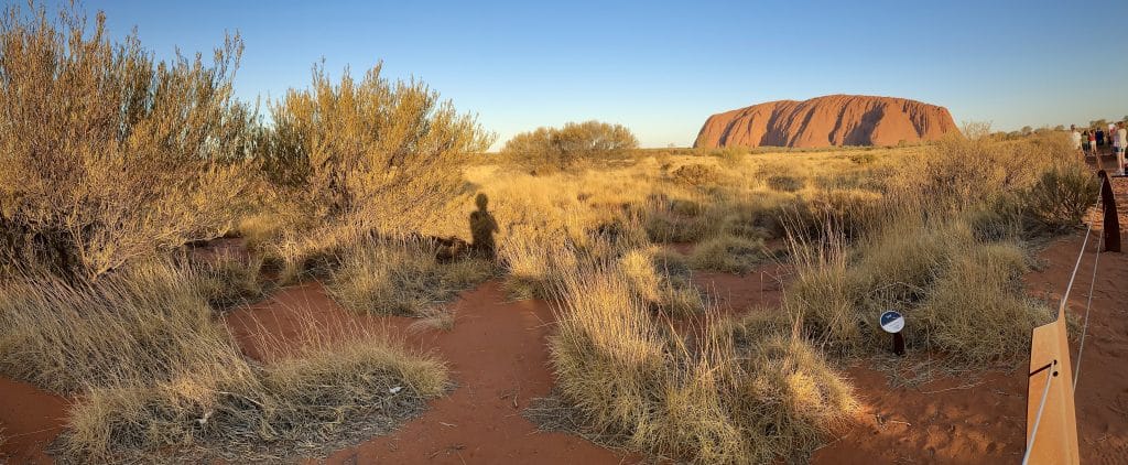 This image shows you a canvass of red earth, light browns, green and blue sky. 
