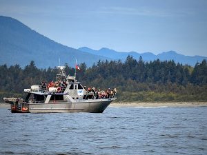 This photographs opens to a seascape featuring a vessel full of people who have been drawn to savour the Pacific’s and beyond sights and sounds.